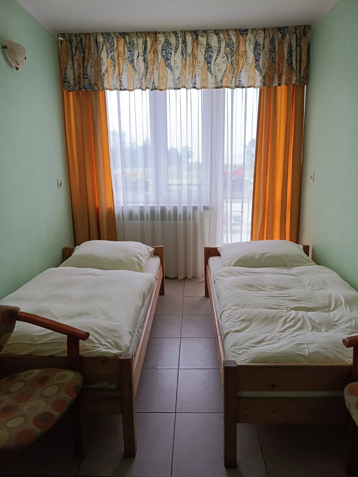 Przykładowy pokój ALKA z dwoma łóżkami i zielonymi ścianami